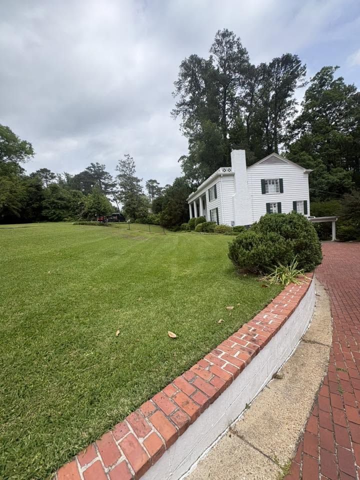 Striped lawn curving along a brick retaining wall