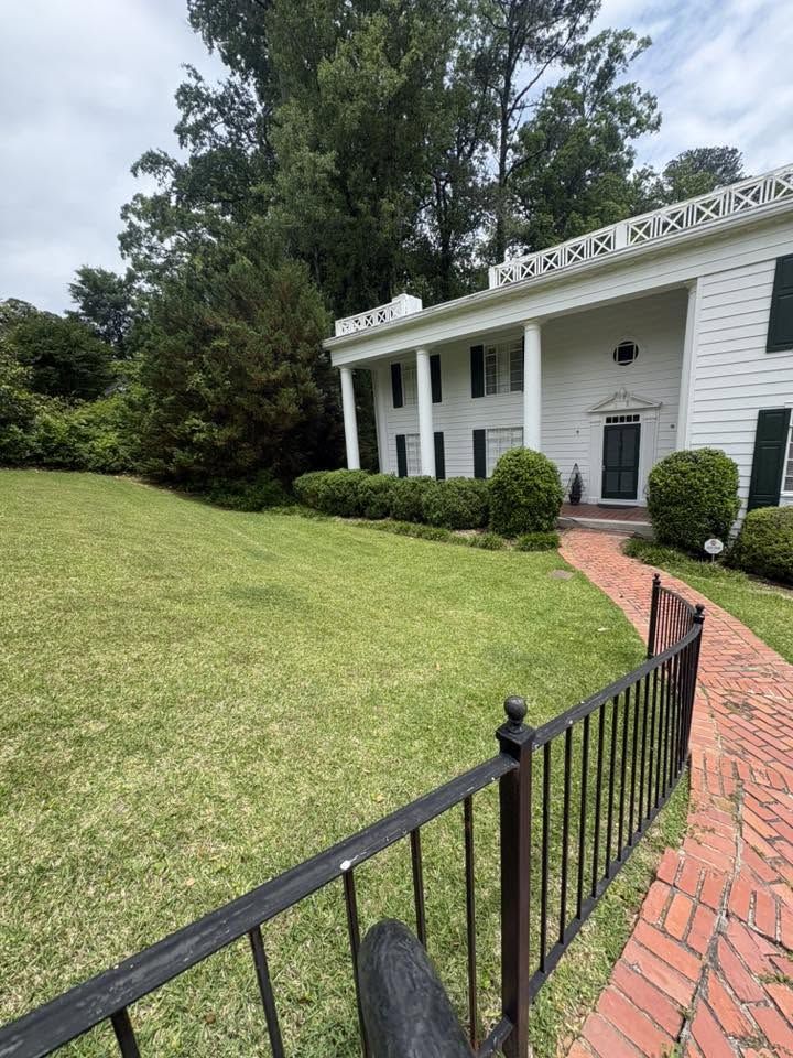 Fresh cut lawn and brick walkway at a white colonial home