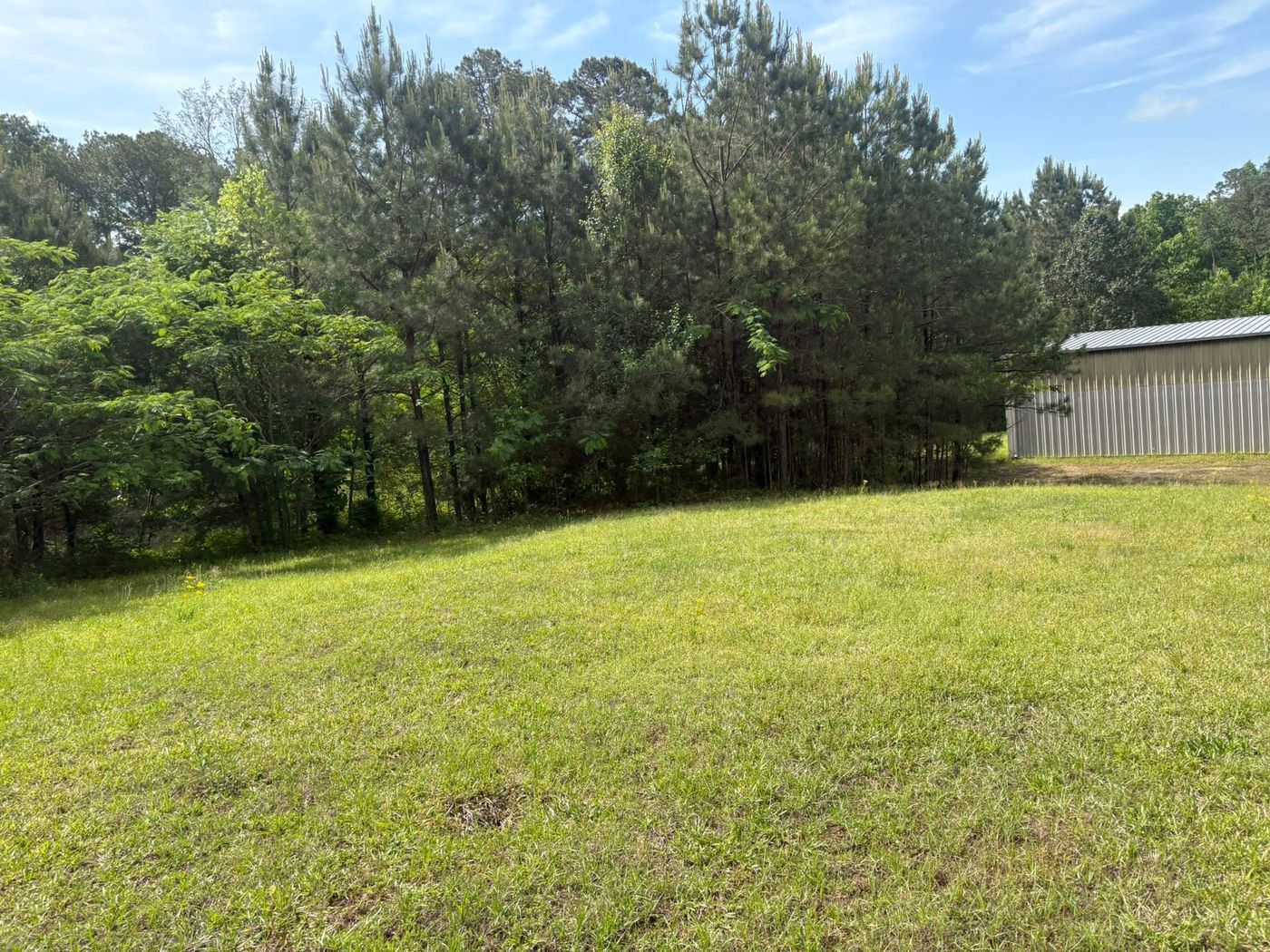 Mowed open field beside a metal barn