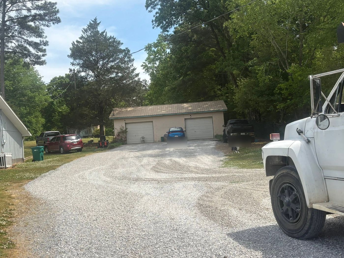 Wide fresh gravel pad in front of a two car garage