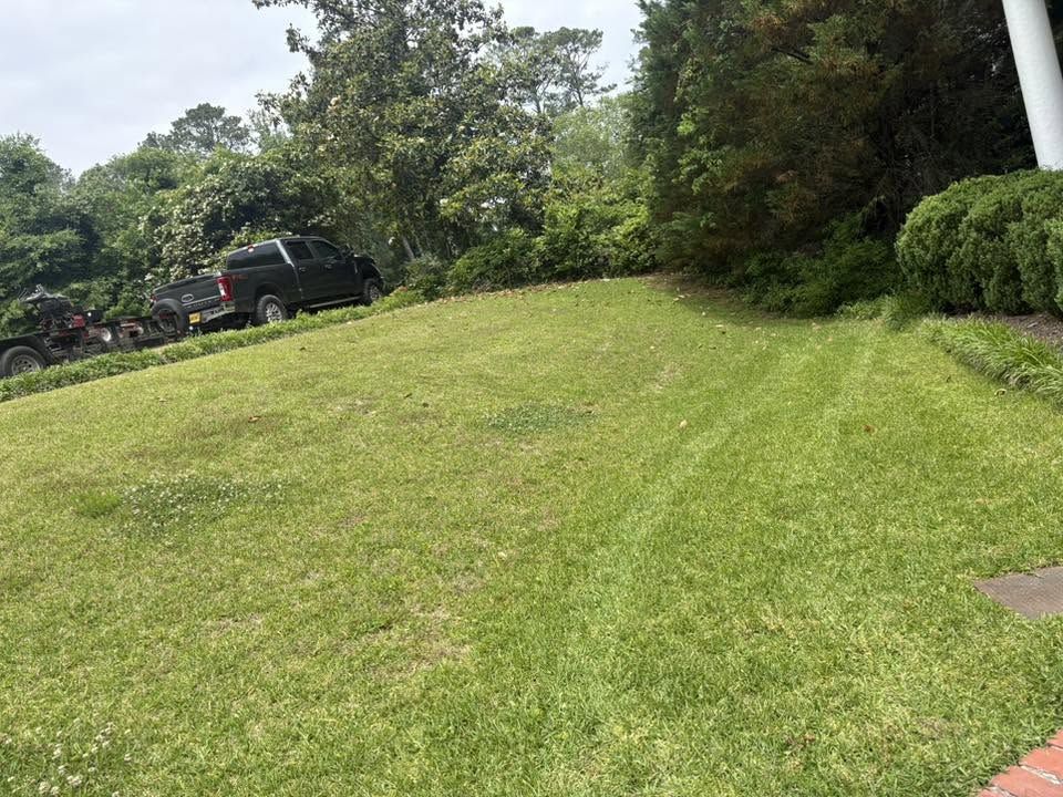 WadeWorks truck and equipment trailer beside a fresh cut lawn