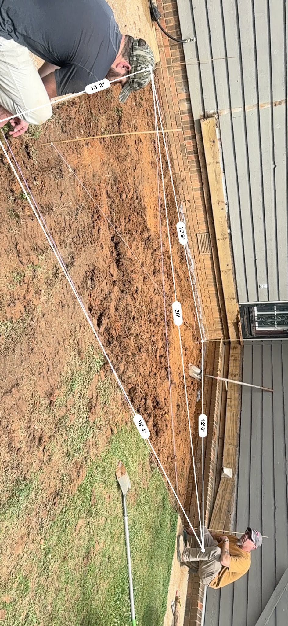 String lines and measurements laid over a graded patio pad