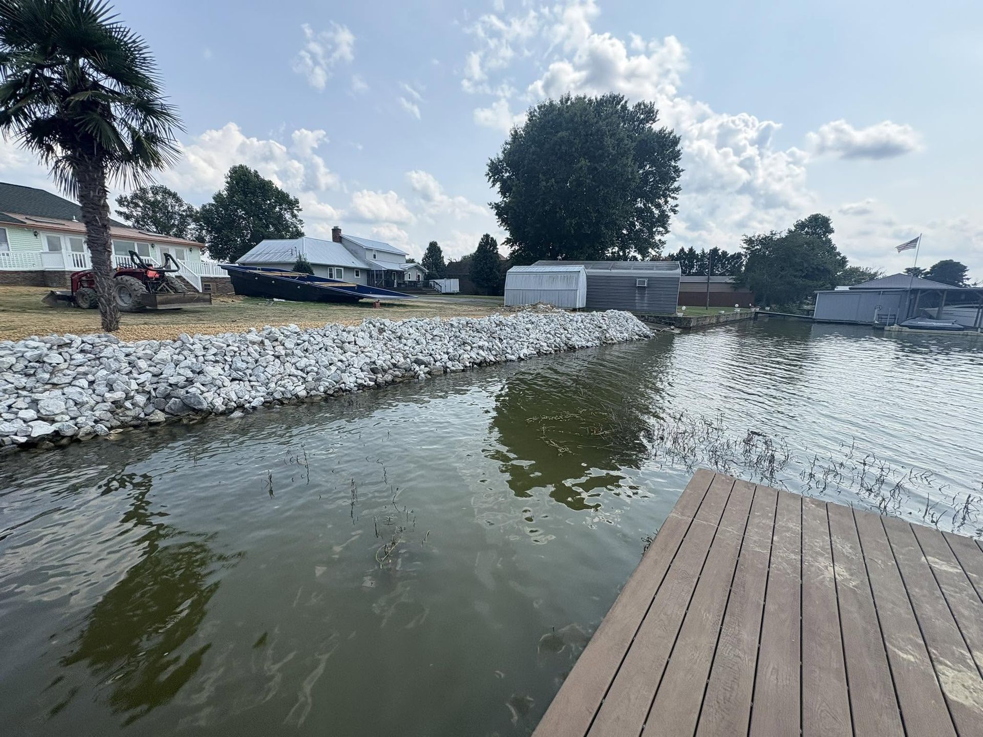 Completed rip-rap shoreline curving along the water, seen from a dock